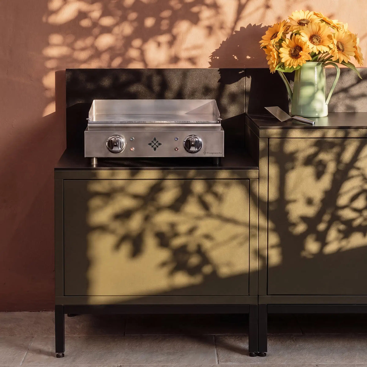 Olive green Pilotis outdoor kitchen with integrated Vivaplancha griddle.
::visuel:noir