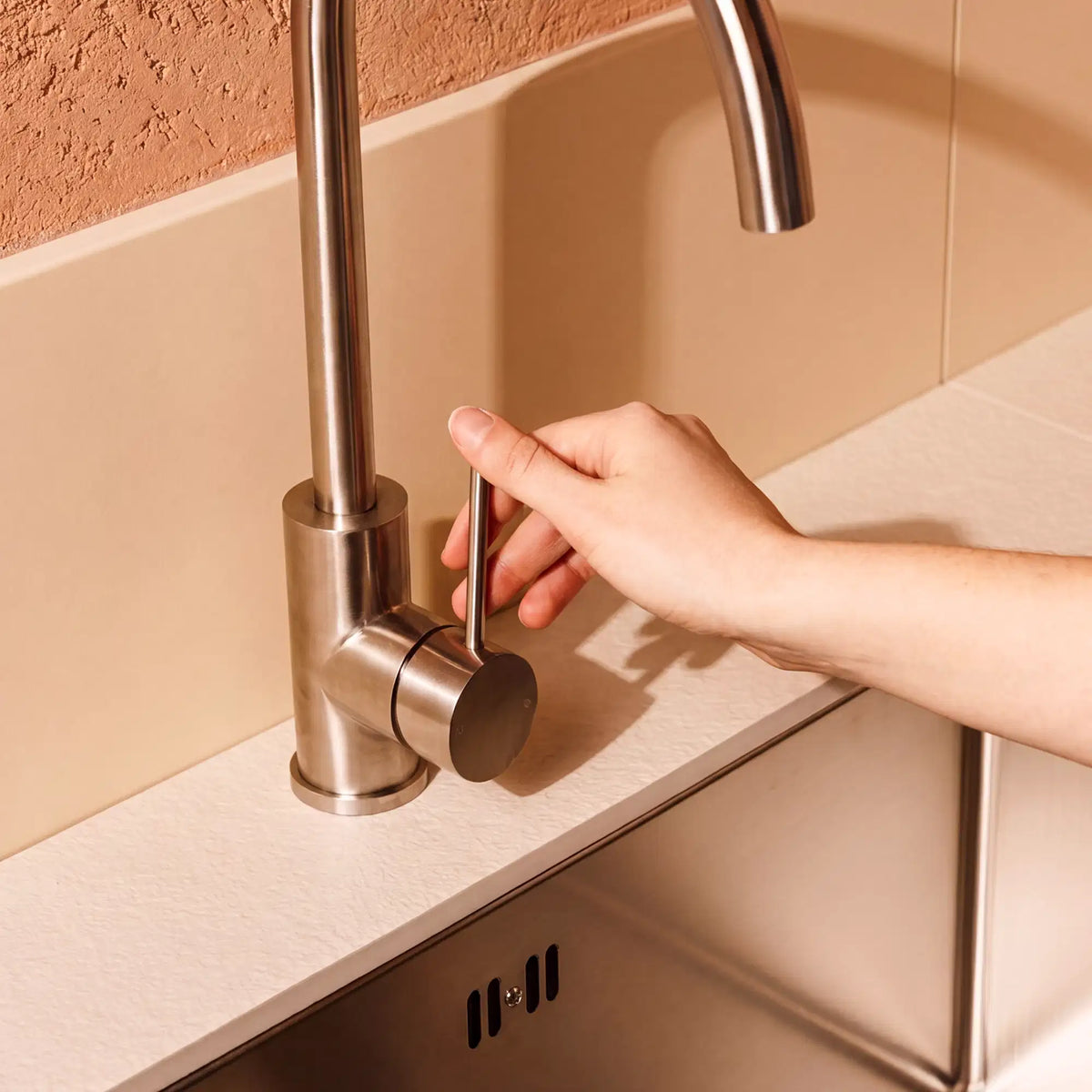 Stainless steel tap fitted on a Pilotis sink module with a cream-white ceramic worktop
::visuel:creme