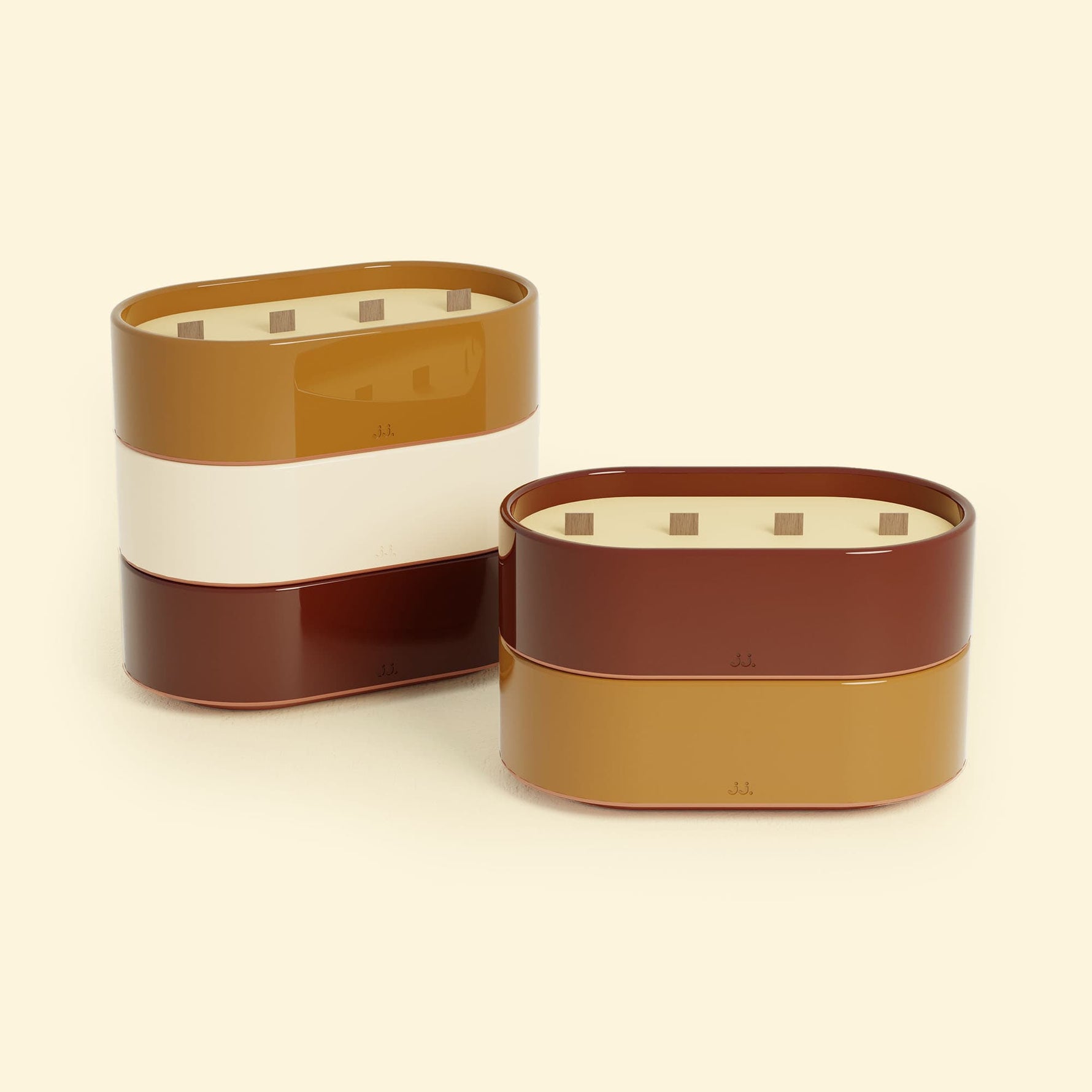 Bougies Totem L Brun terre de sienne – Citronnelle & Fleur d’oranger et Rouge oxyde – Citronnelle & Géranium, deux grandes bougies ovales à triple mèche en bois, posées sur un fond beige clair.