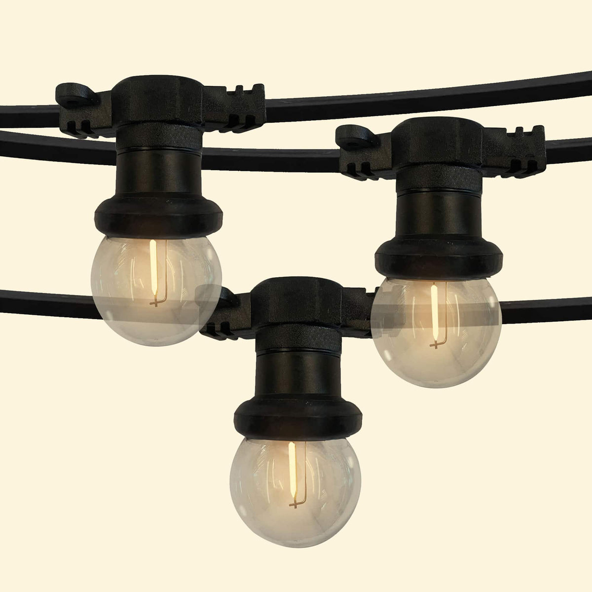 Guirlande lumineuse d’extérieur avec ampoules rondes transparentes à filament LED, montées sur un câble noir résistant, parfaite pour éclairer et décorer terrasses, pergolas ou jardins.