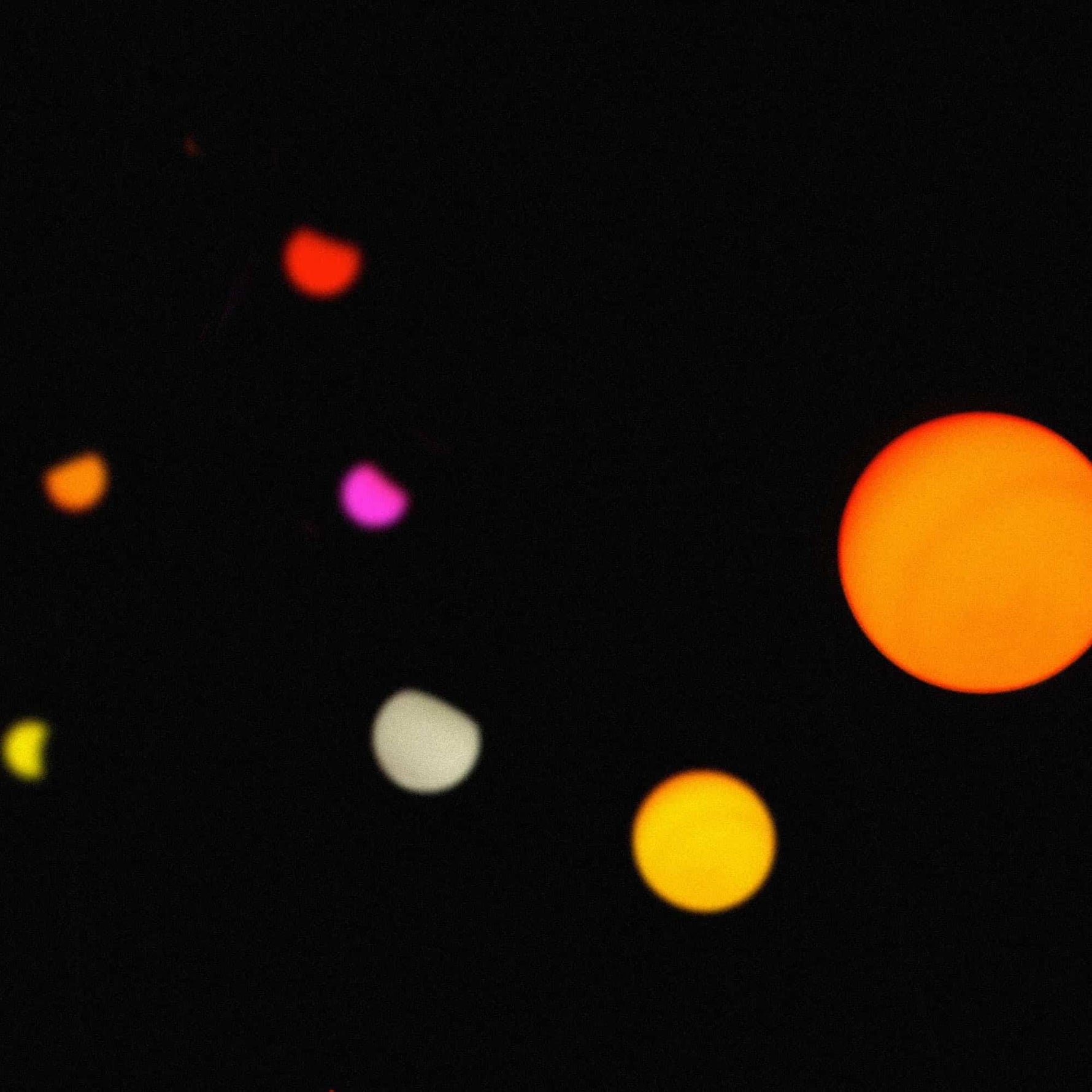 Guirlande lumineuse Sunset allumée de nuit, diffusant une lumière colorée avec des ampoules rouges, jaunes, oranges et roses pour une ambiance chaleureuse.