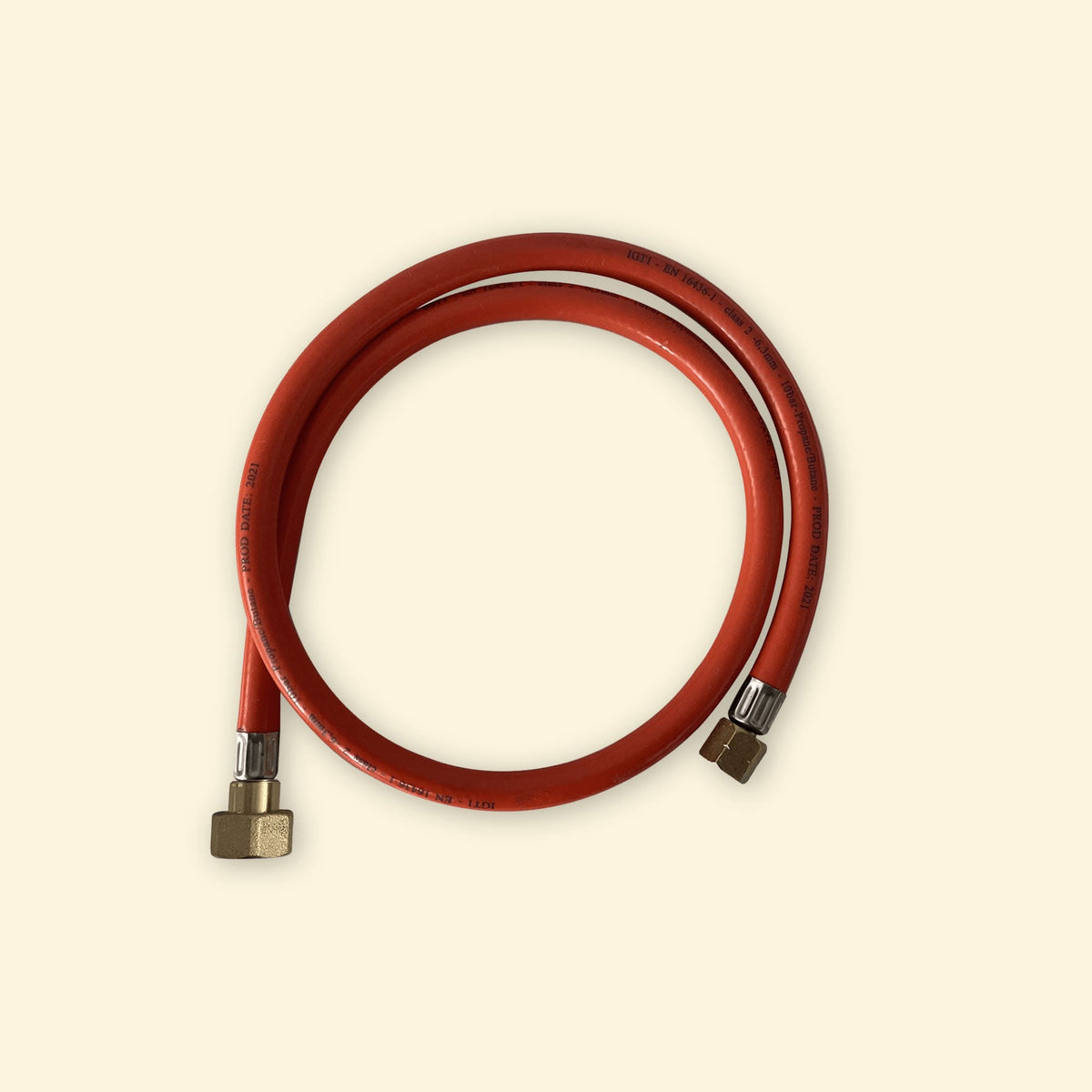 Tuyau de gaz rouge avec embouts métalliques pour installation Royaume-Uni/Pays-Bas, présenté enroulé sur fond uni clair.